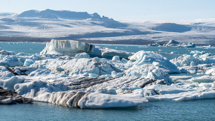 A beautiful icebergs breaking from Vatnajokull glacier and drifting across Jokulsarlon lagoon, Iceland, reflecting glacier melt and global warming in a striking summer landscape. © Asanee