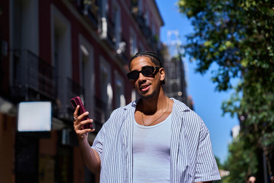 Young man using smartphone on city street