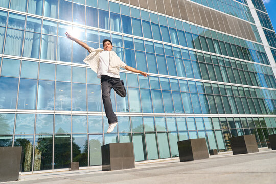 Young man jumping with joy in urban area