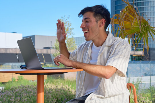 Young man using laptop for video call outdoors