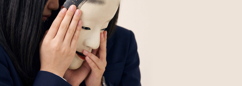 Businesswoman Hiding Behind a Mask Expressing Hidden Identity, Secrecy and Deception with Copy Space
