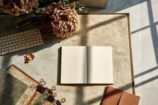 Open blank notebook on a desktop with a keyboard, peonies, and stationery, featuring soft daylight and copy space for a mockup template