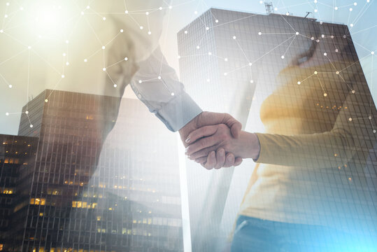 Woman and man shaking hands in office; multiple exposure