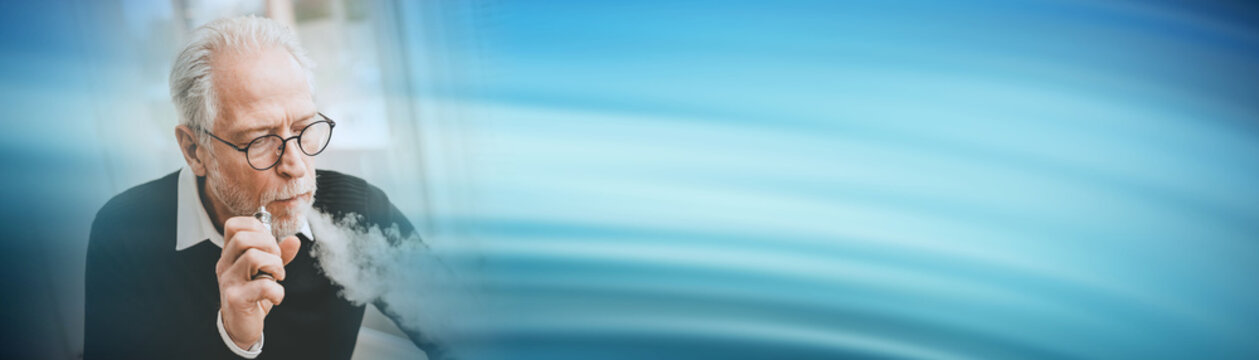 Senior man smoking electronic cigarette; panoramic banner