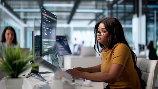 Young Woman Developer Compares Coding Changes On Laptop