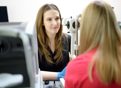 Examination of eyesight of woman by ophthalmologist. Patient during visit to optometrist for analysis of eyelids, sclera, conjunctiva, iris, lens, cornea. Eye exam