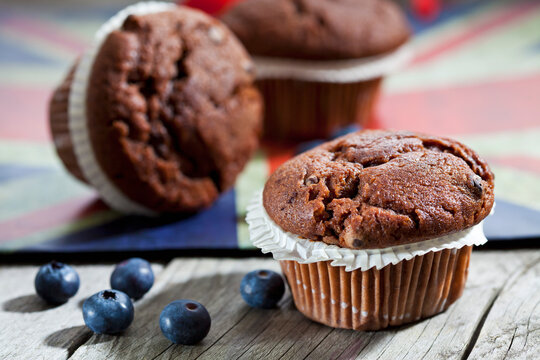 Chocolate muffins and blueberries on wood, English flag