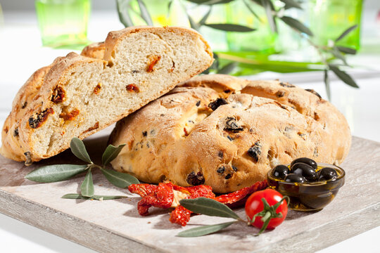 Loaf of bread with olive and tomato, close up