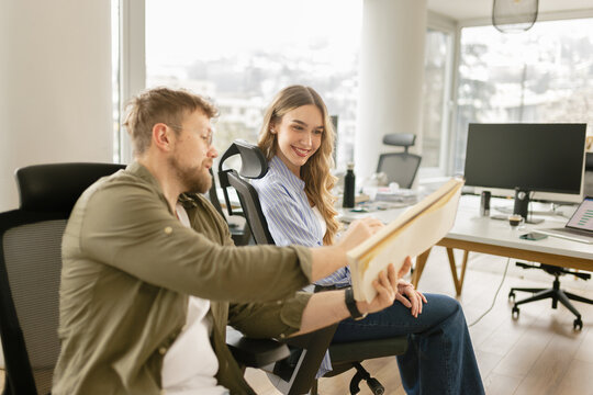 A man explains an idea to a woman in a modern office