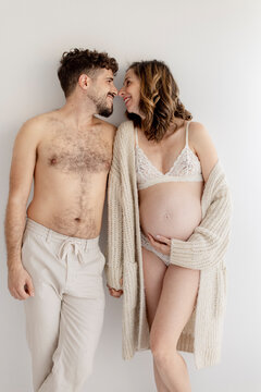 Pregnant woman and man share a loving moment indoors