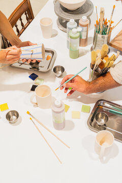 Man and woman paint ceramic pottery in an art studio