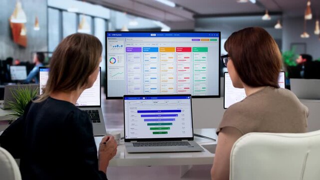 Sales Manager And Assistant Analyze Client Data Using CRM