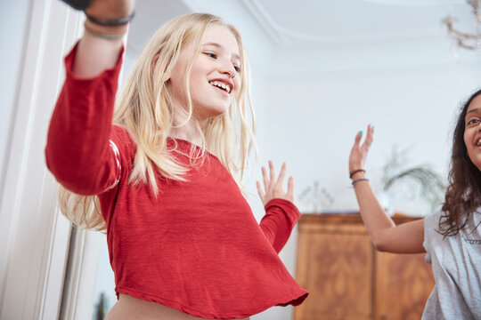 Two happy girls dancing at home