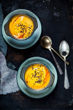 Two bowls of creamed pumpkin soup sprinkled with black cumin