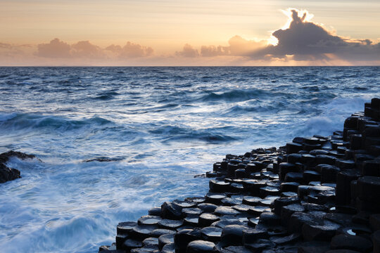 Giant's Causeway basalt columns and ocean waves at sunset, Northern Ireland