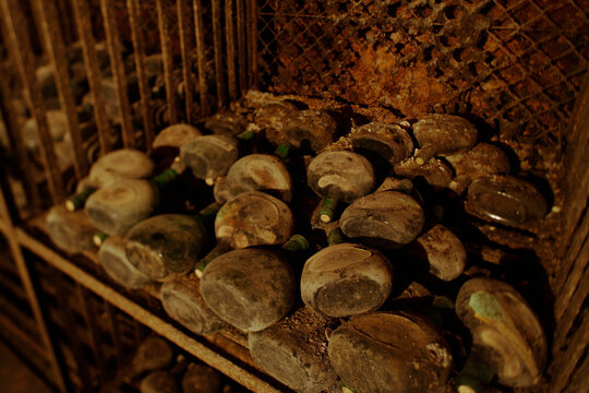 Old wine bottles on shelf in cellar