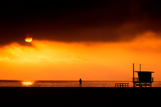 USA, California, Santa Monica State Beach, Rear view of nude man standing on beach at sunset