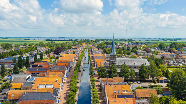 Aerial view of a historic canal village with church and traditional boats in Europe
