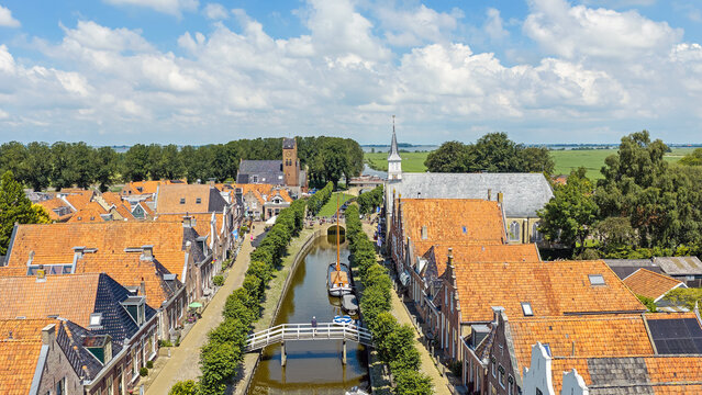 Aerial view of a historic canal town with churches and traditional boat in Europe