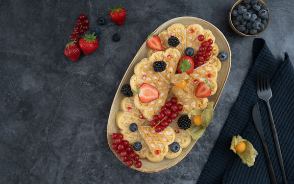 Fruit Pancake Platter with Berries and Figs. Overhead breakfast platter featuring pancakes topped with fresh berries, figs and seasonal fruit