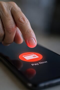 Senior Safety concept shows Finger about to tap a "Pay Now" button on a smartphone screen.