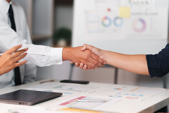Business professionals shaking hands over office table for deal partnership