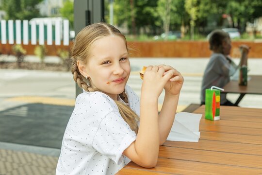 Child Eating Burger at Fast Food Restaurant