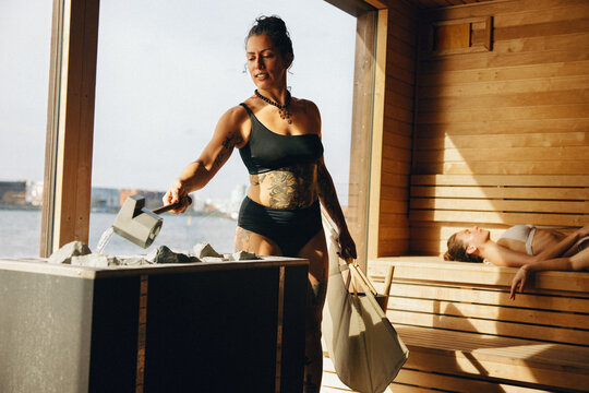 Sauna master performing sauna ritual with water and steam for spa wellness and relaxation