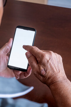 Senior adult hands holding and touching a smartphone with a blank white screen, symbolizing connection, communication, and digital technology for elderly people