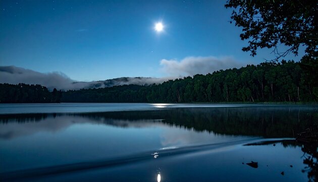Bright full moon illuminating a calm lake surrounded by dark forest trees and low rolling clouds with water surface