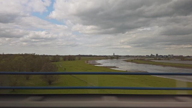 View from a car driving on the A1 highway over the IJssel river with Deventer skyline in background