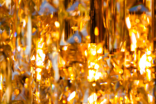 Macro close up of faceted golden crystal chandelier pattern texture background