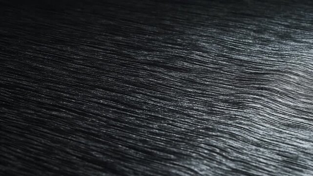 Dark black wood surface with natural grain texture and subtle diagonal pattern