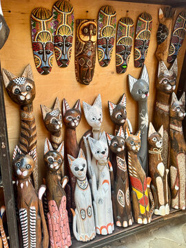 Hand carved wooden cat statues and decorative masks at souvenir market in Old Town Nesebar Bulgaria. Traditional handmade wooden crafts and folk art.