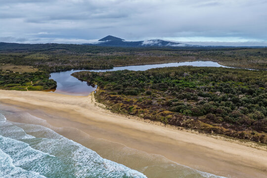 Aerial view of Lake Arragan Beach and Lake Arragan within Yuraygir National Park, showcasing the sandy Pacific coastline, coastal lake, native bushland and surrounding natural landscape.
