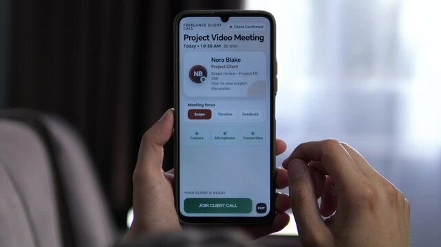 Freelancer prepares for a scheduled client video meeting on a smartphone, checking camera, microphone and connection before joining a remote project discussion.