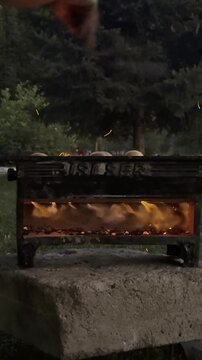 Vertical Video of Lighting Charcoal and Fanning Flames for Outdoor Barbecue Grill