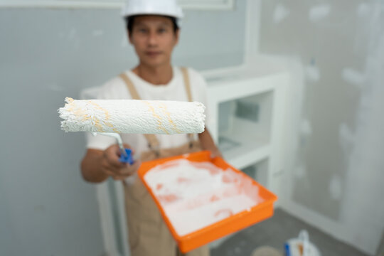 painter man, brush in hand for products to restore and paint the wall, indoor the building site of a house, wall during painting, renovation, painting, contractor, Architect, construction worker