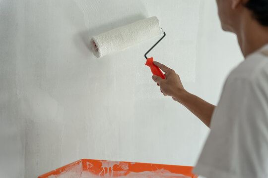 painter man, brush in hand for products to restore and paint the wall, indoor the building site of a house, wall during painting, renovation, painting, contractor, Architect, construction worker