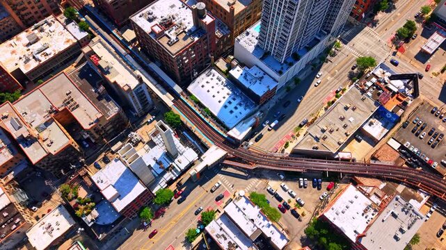 Intersection with elevated train tracks and urban traffic, Chicago. Top-down view of city streets, cars and commercial buildings.