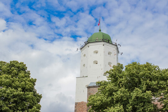 A rusty-domed stone tower nestled among trees in the open air showcases the historic architecture and natural surroundings.