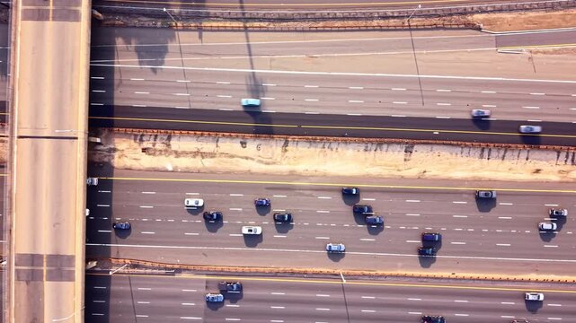 Aerial view of highway lanes and bridge structure. Overhead drone shot of parallel roadways, dashed lane markings, and vehicle shadows. Garden State Parkway
