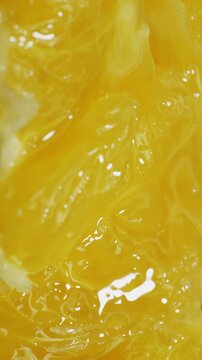 Orange Pulp Compressed in Macro View. Juicy citrus vesicles deform and release liquid under steady pressure.