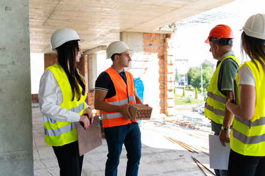 Female engineers and builders discuss building layout. Special documents allows to review project features and construction details