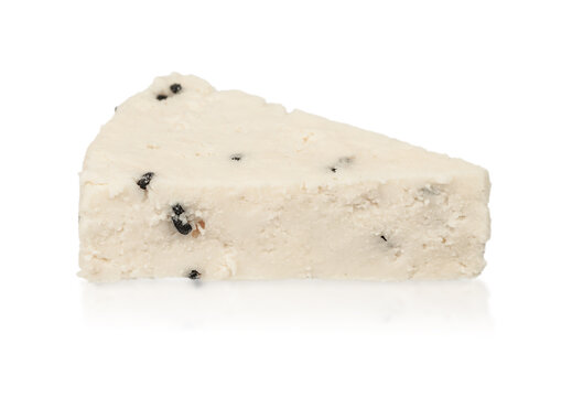 Triangular piece of white cheese with black specks on a reflective surface, showcasing a smooth texture and clean edges, suitable for culinary presentations or food photography