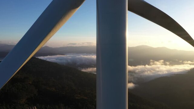 Aerial view of wind turbines rising above the green tea plantations of Cau Dat, Xuan Truong Ward, Da Lat, Lam Dong, Vietnam, showcasing renewable energy and highland landscapes.