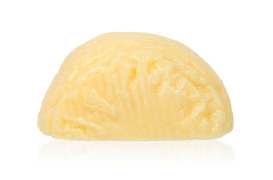 Yellow butter block with a smooth surface and textured pattern, placed on a reflective white background for culinary and food photography use