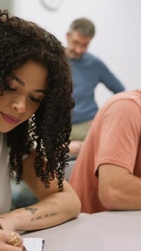 Diverse university students taking notes during a classroom lecture