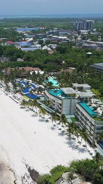 Vertical drone flyover pans left over Alona Beach, showing white sand, shallow turquoise water, beachfront resorts, and the Panglao coast