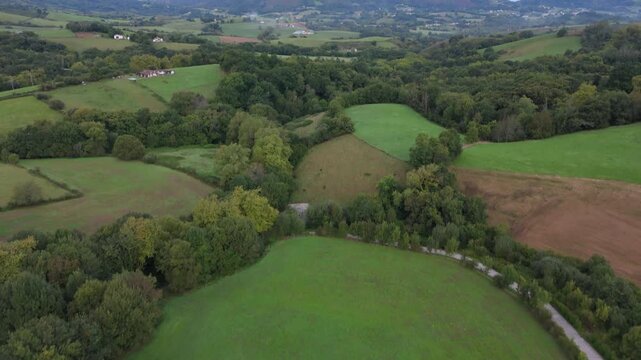 Aerial drone camera tilt up revealing green valley and mountains near Zugarramurdi village, Navarra, Spain